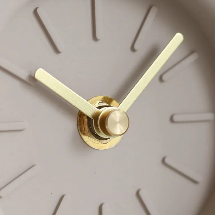Round cement silent desk clock with Nordic minimalist design on wooden surface