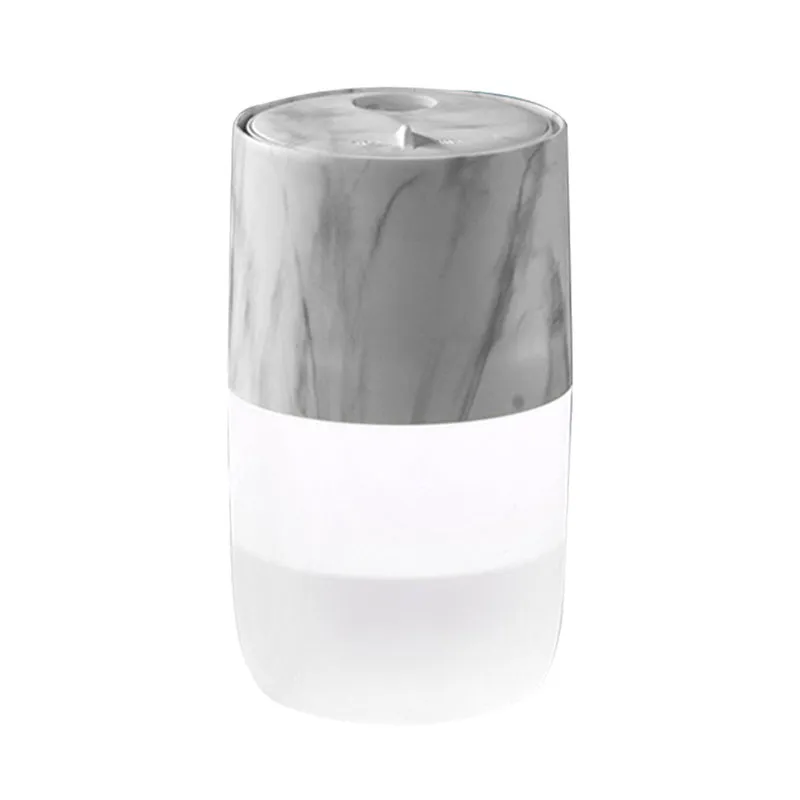 Mini portable jellyfish-shaped ultrasonic humidifier in black, with USB cable and essential oil bottle on a desktop