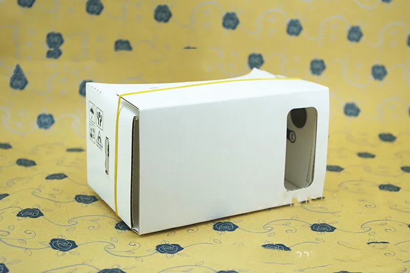 Foldable pink and white VR cardboard glasses headset for smartphones with adjustable strap and 3D lenses.
