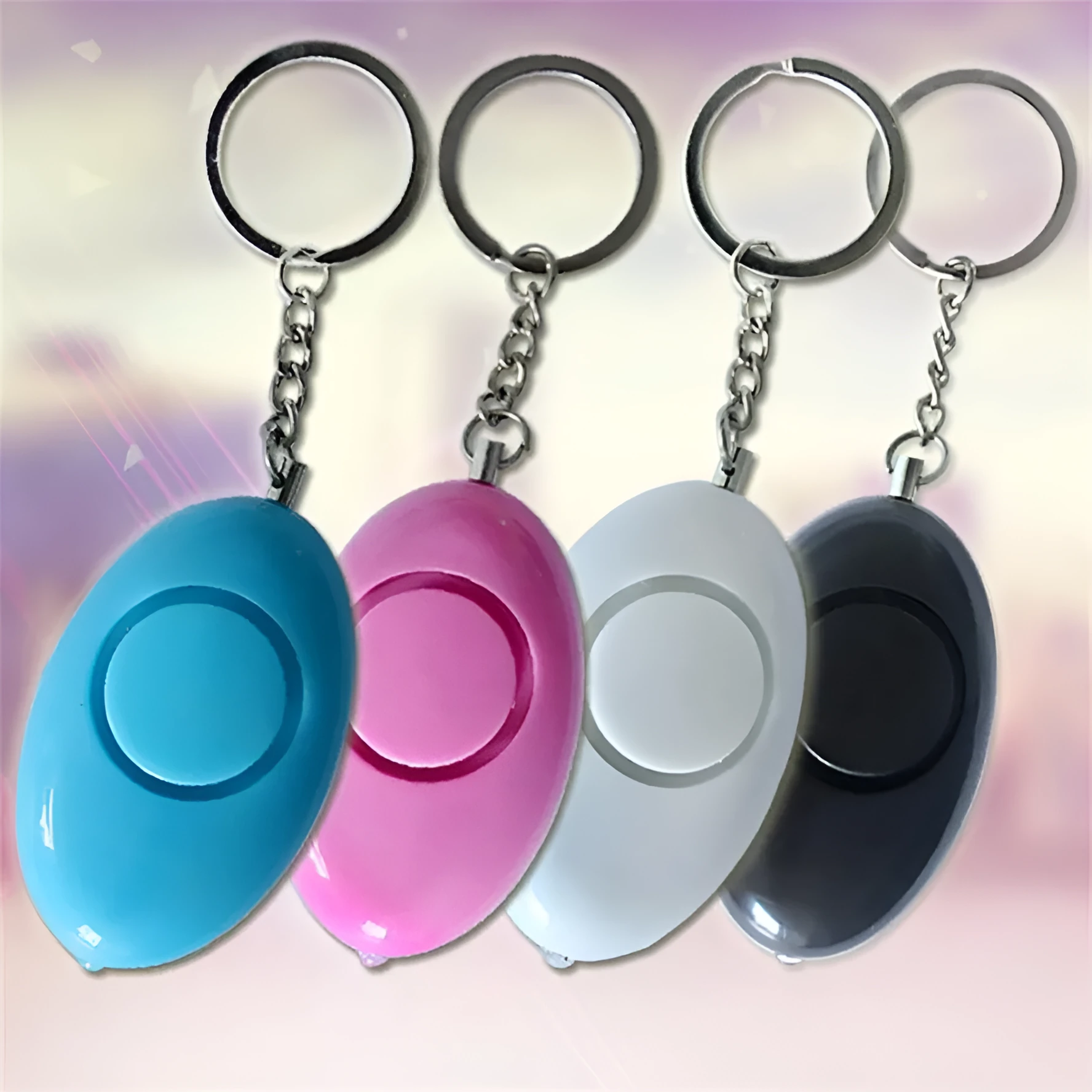Egg-shaped personal safety alarm keychain in pink with metal pin on a white background