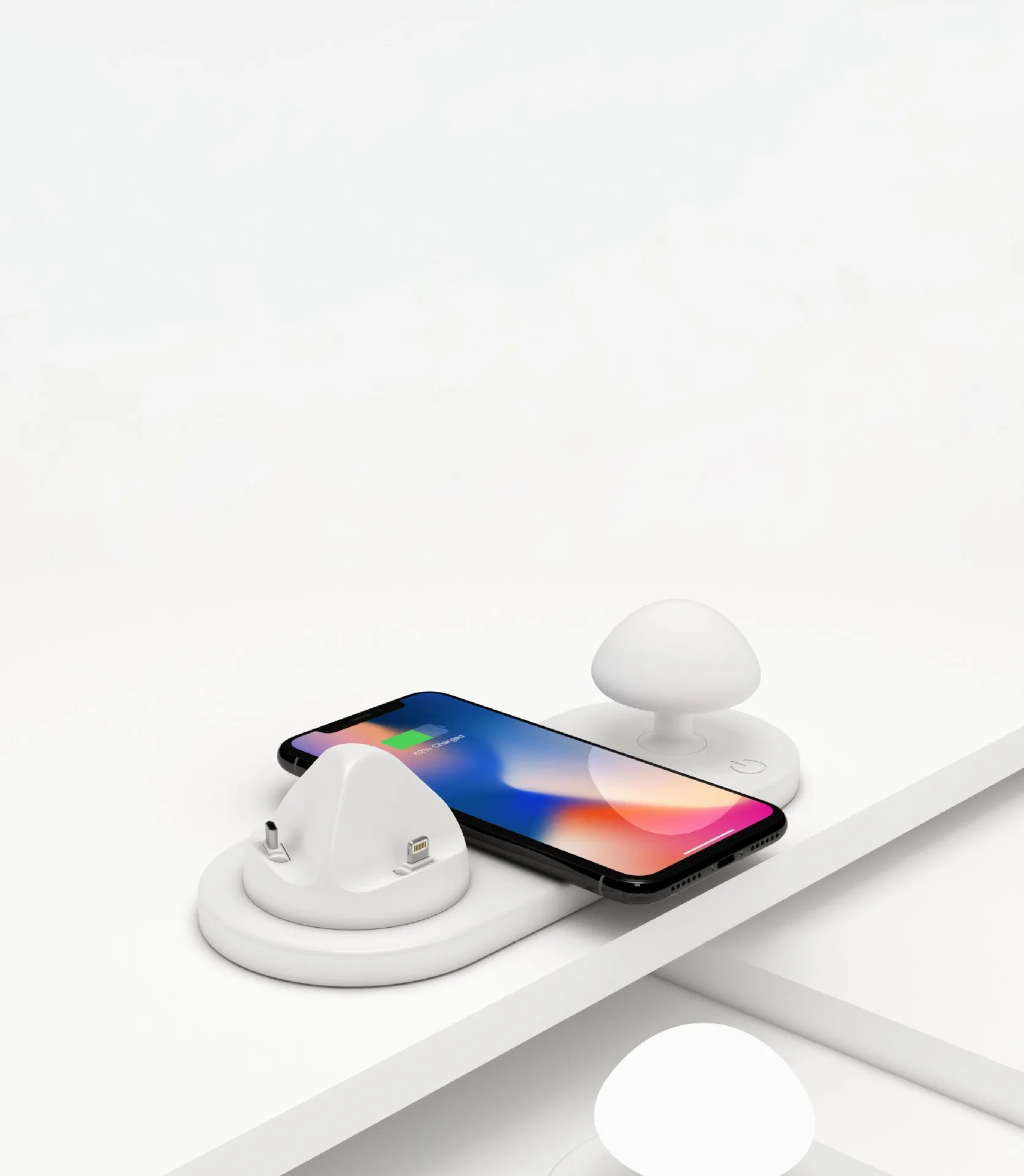 White 3 in 1 wireless charging dock with a phone on the pad and USB cable
