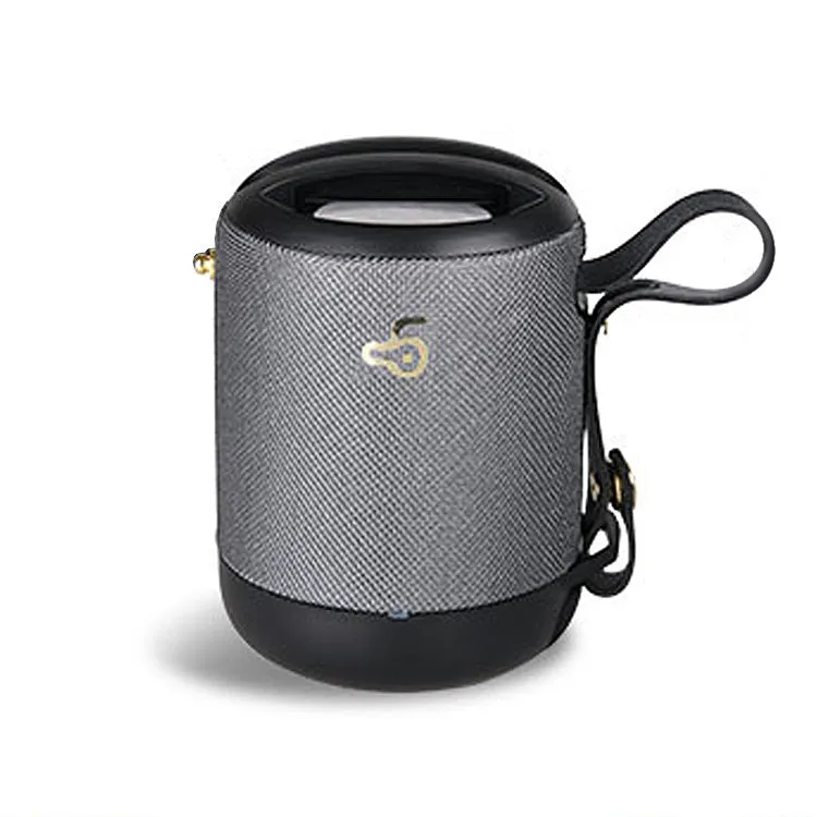 Compact black waterproof bluetooth speaker with portable belt on a table