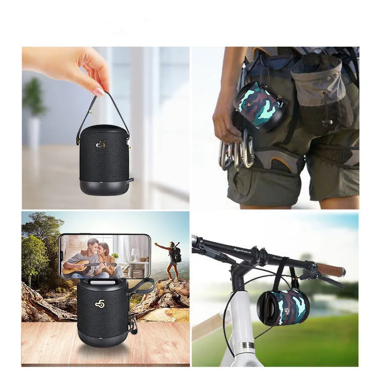 Compact black waterproof bluetooth speaker with portable belt on a table
