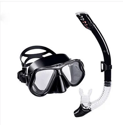 Black diving goggles with clear anti-fog lens, polycarbonate frame, and blue silicone skirt on an adjustable strap.