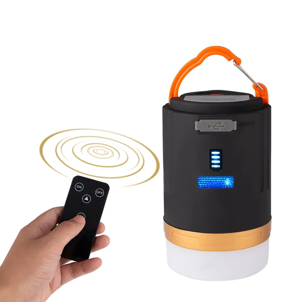Black rechargeable LED camping light with hanging hook and remote control on a table