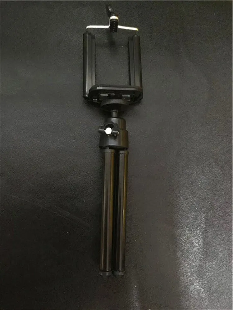 Black and silver desktop phone holder with a two-section adjustable bracket on a wooden desk.