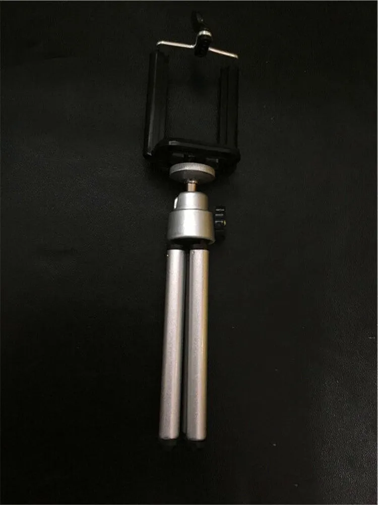 Black and silver desktop phone holder with a two-section adjustable bracket on a wooden desk.