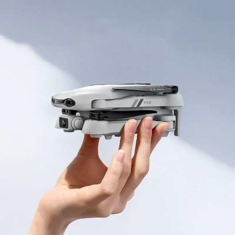 F10 folding GPS drone with 6K dual camera unfolded on a table showing propellers and camera