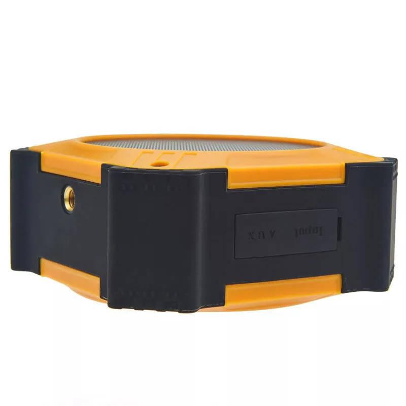 Compact black waterproof Bluetooth speaker with a wrist strap, shown next to a charging cable.