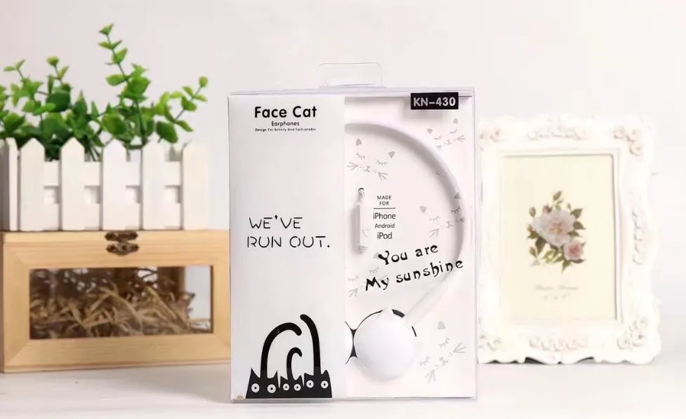 Kitten ear headphones in black with head-mounted design and 3.5mm plug on a desk next to a laptop.