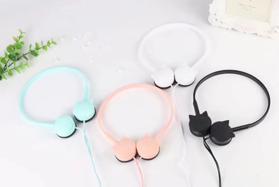 Kitten ear headphones in black with head-mounted design and 3.5mm plug on a desk next to a laptop.