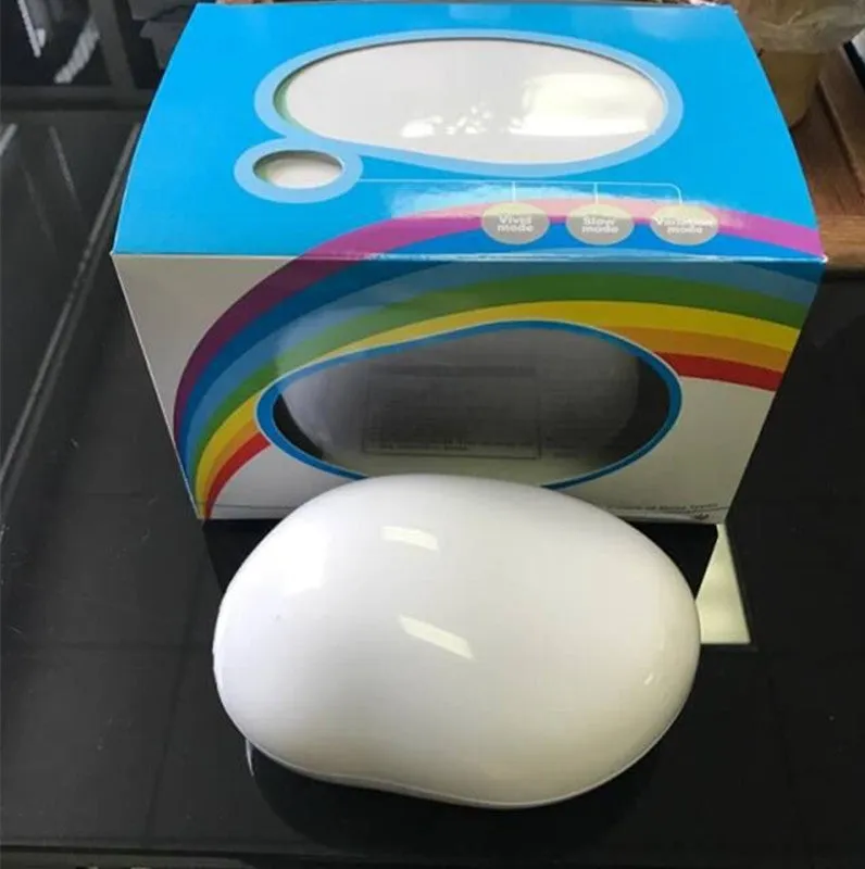 Egg-shaped white rainbow projection lamp with three lighting modes, 14x10x6cm, on a table