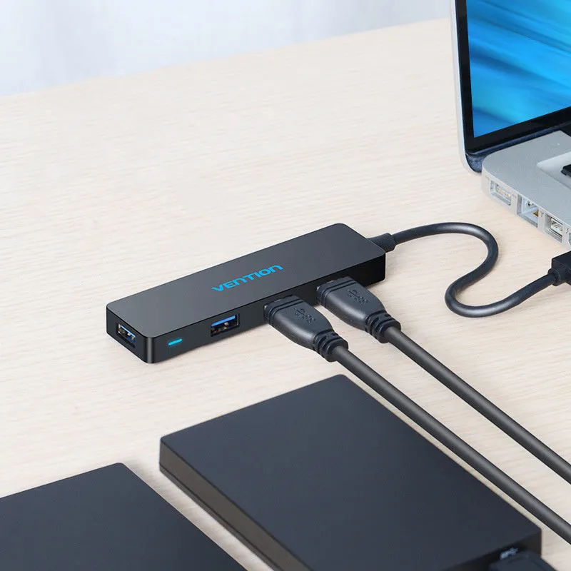 Black four-port USB 3.0 hub with a short 15cm cable on a desk