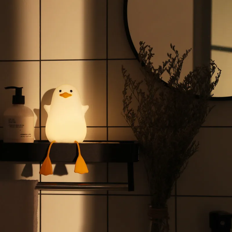Little Gull rechargeable silicone night light in blue mouth on a bedside table