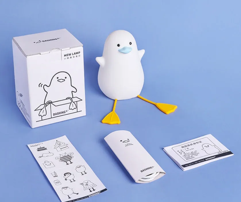 Little Gull rechargeable silicone night light in blue mouth on a bedside table
