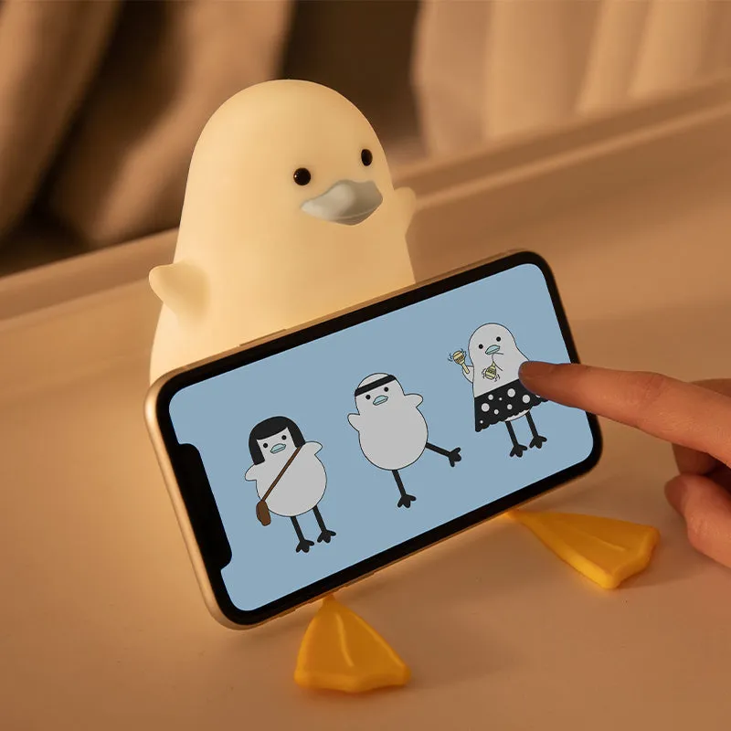 Little Gull rechargeable silicone night light in blue mouth on a bedside table