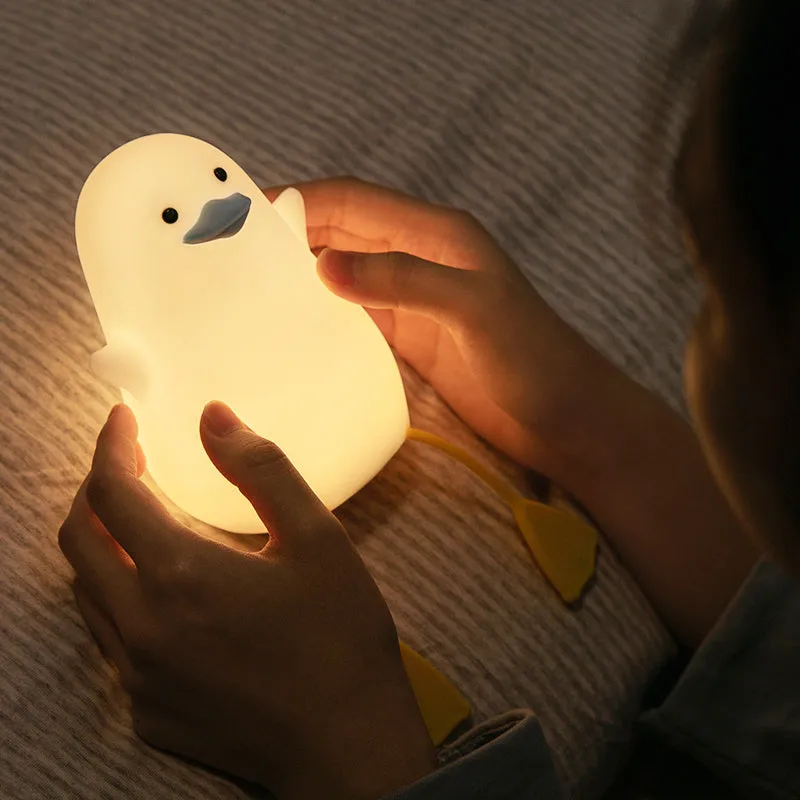 Little Gull rechargeable silicone night light in blue mouth on a bedside table