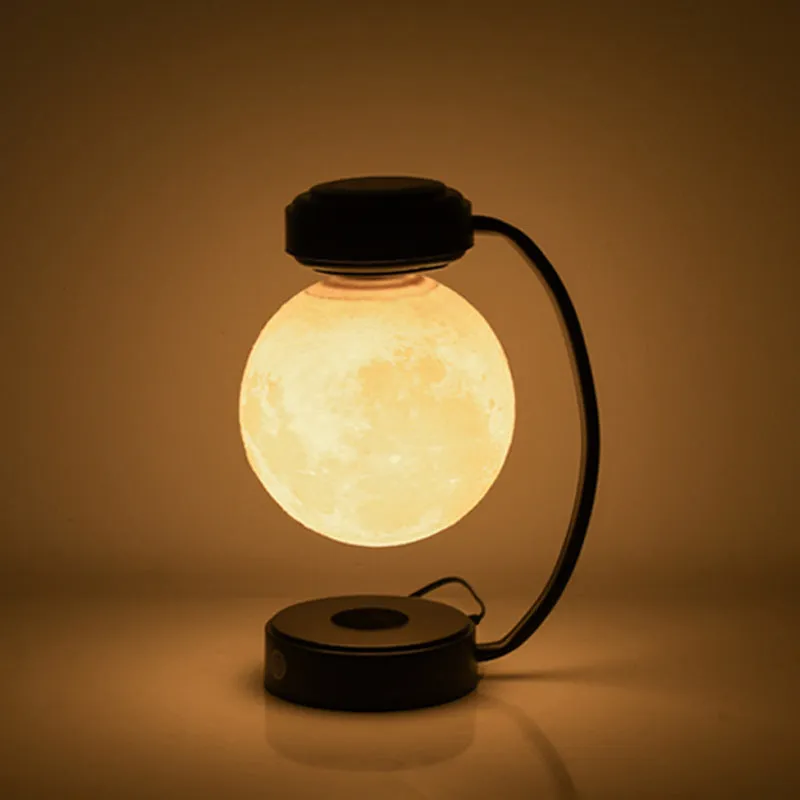 3D LED moon night light with magnetic levitation, floating ball, iron base, black finish on a desk