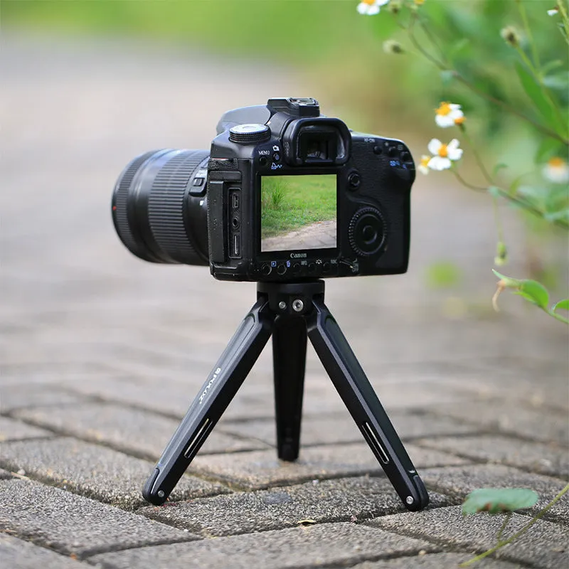 Metal mini tripod with non-slip rubber feet, 15cm max height, black, on uneven outdoor surface