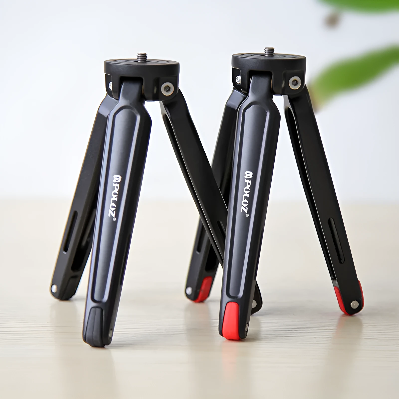 Metal mini tripod with non-slip rubber feet, 15cm max height, black, on uneven outdoor surface