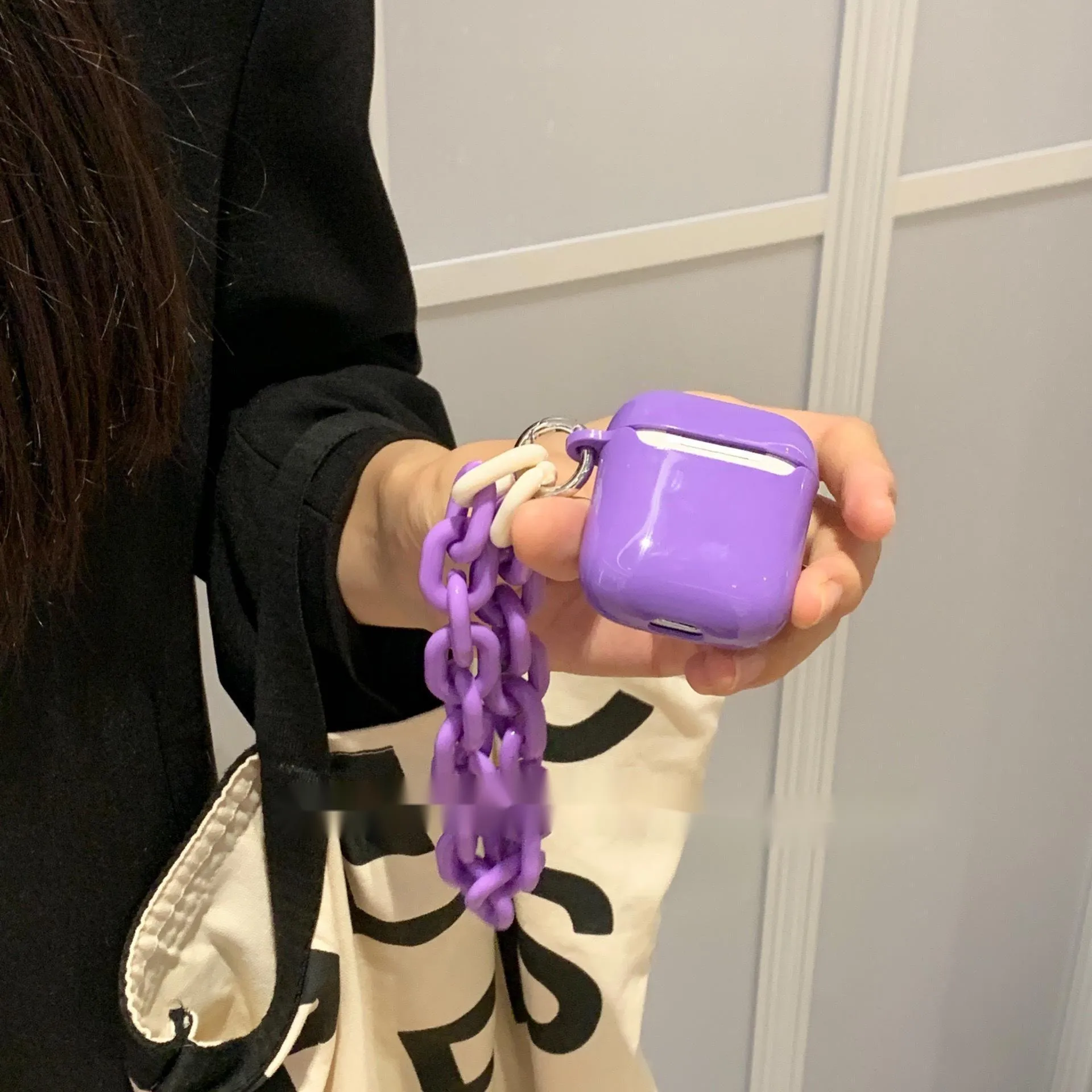 Silicone protective sleeve for AirPods case in green and purple colours with chain earphone shell design