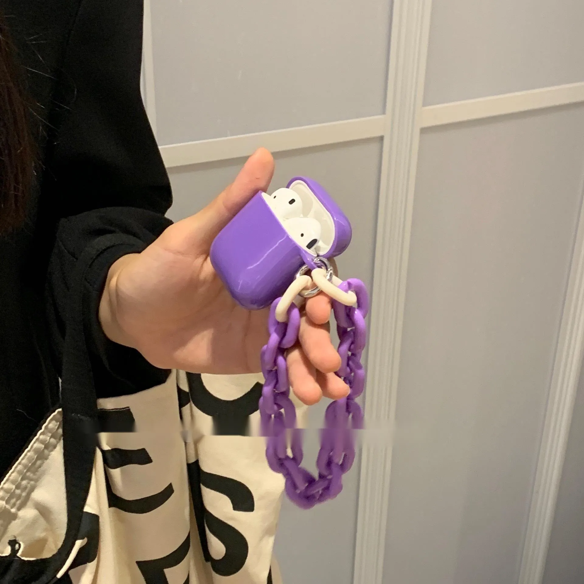 Silicone protective sleeve for AirPods case in green and purple colours with chain earphone shell design