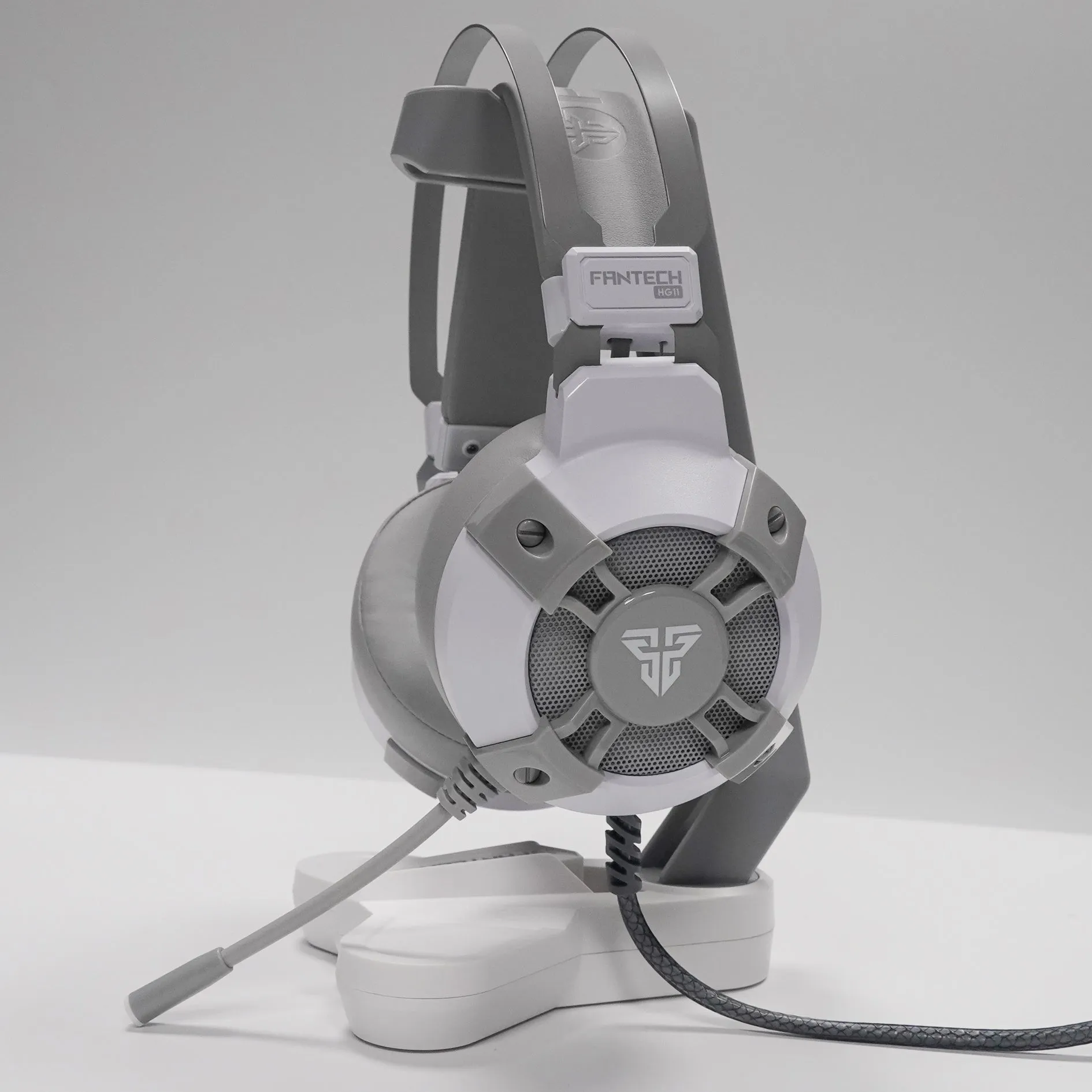 Black FANTECH HG11 USB gaming headset with over-ear cups and RGB lighting on a stand.