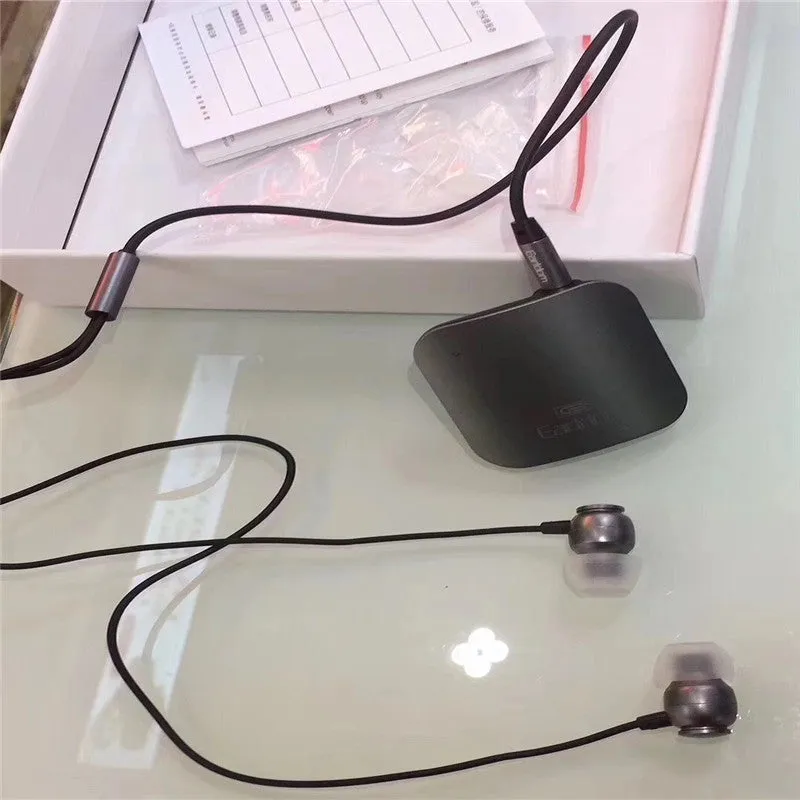Black Bluetooth lavalier headset with earpiece and control unit, shown with packaging.