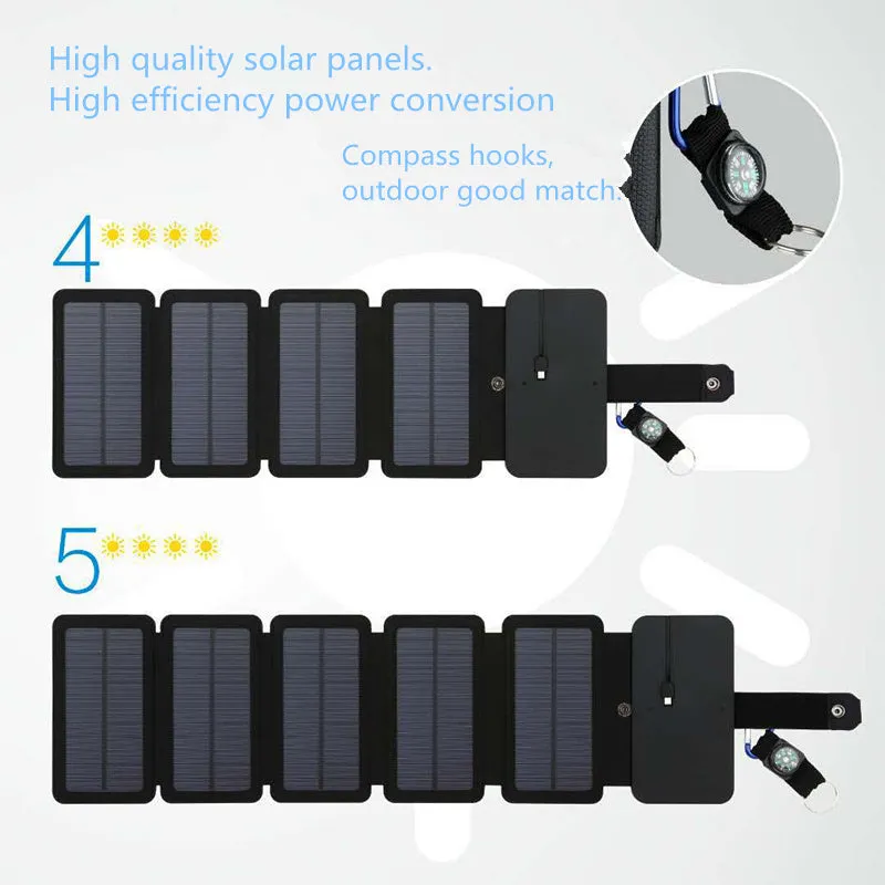 Black folding solar panel charger with monocrystalline cells and USB output, folded flat on a wooden surface, compass buckle visible
