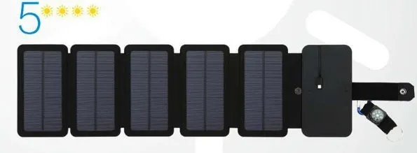 Black folding solar panel charger with monocrystalline cells and USB output, folded flat on a wooden surface, compass buckle visible