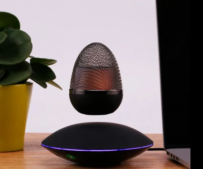 Levitating floating speaker with magnetic suspension, cast FRP body, black colour, hovering above base on a desk