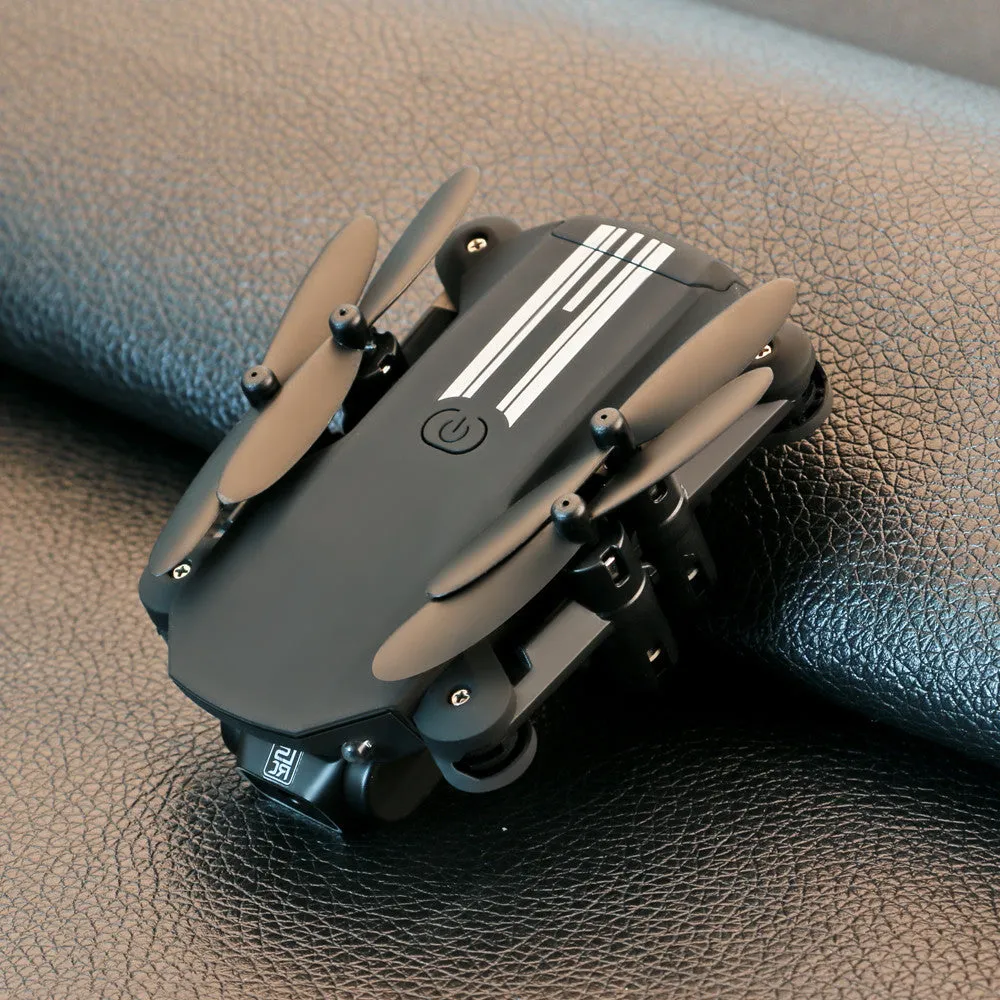 Mini folding aerial drone with 4K camera, open on a flat surface, showing foldable arms and LED lights