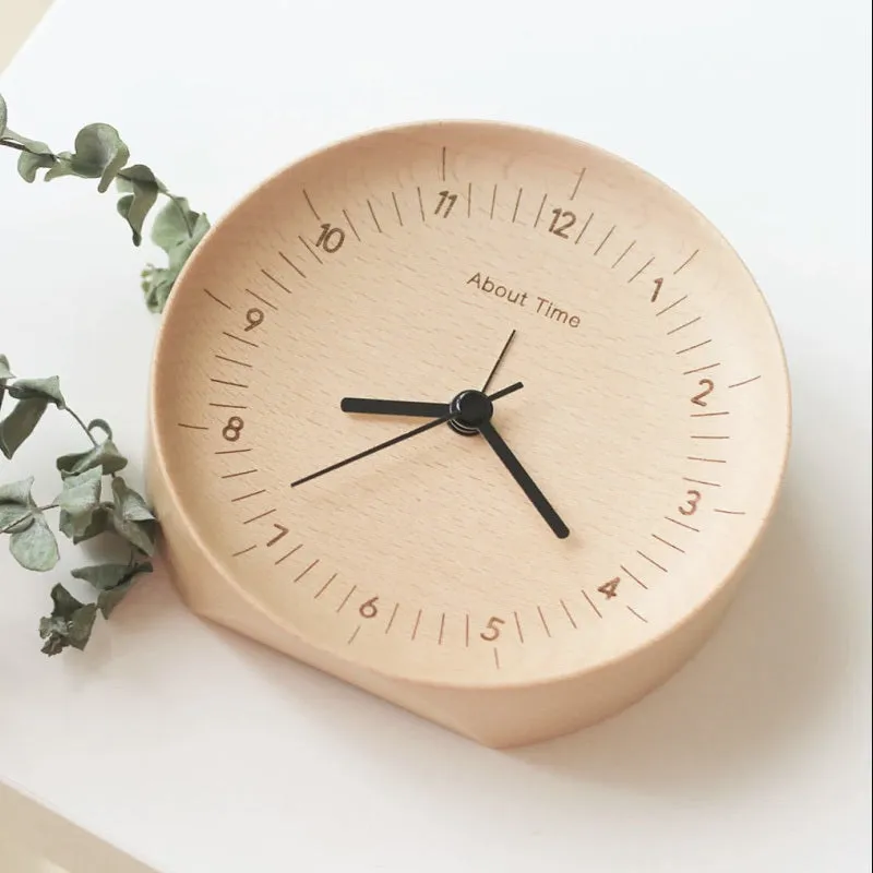 AboutTime log mute pendulum alarm clock in German beech wood, 12cm diameter, featuring Sun brand movement, on a simple desk