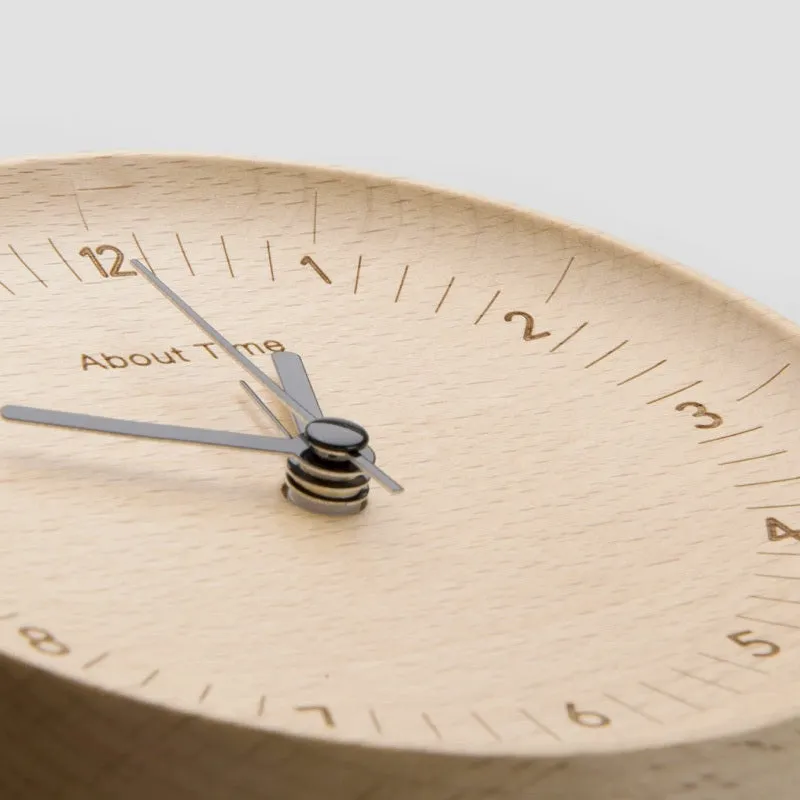 AboutTime log mute pendulum alarm clock in German beech wood, 12cm diameter, featuring Sun brand movement, on a simple desk