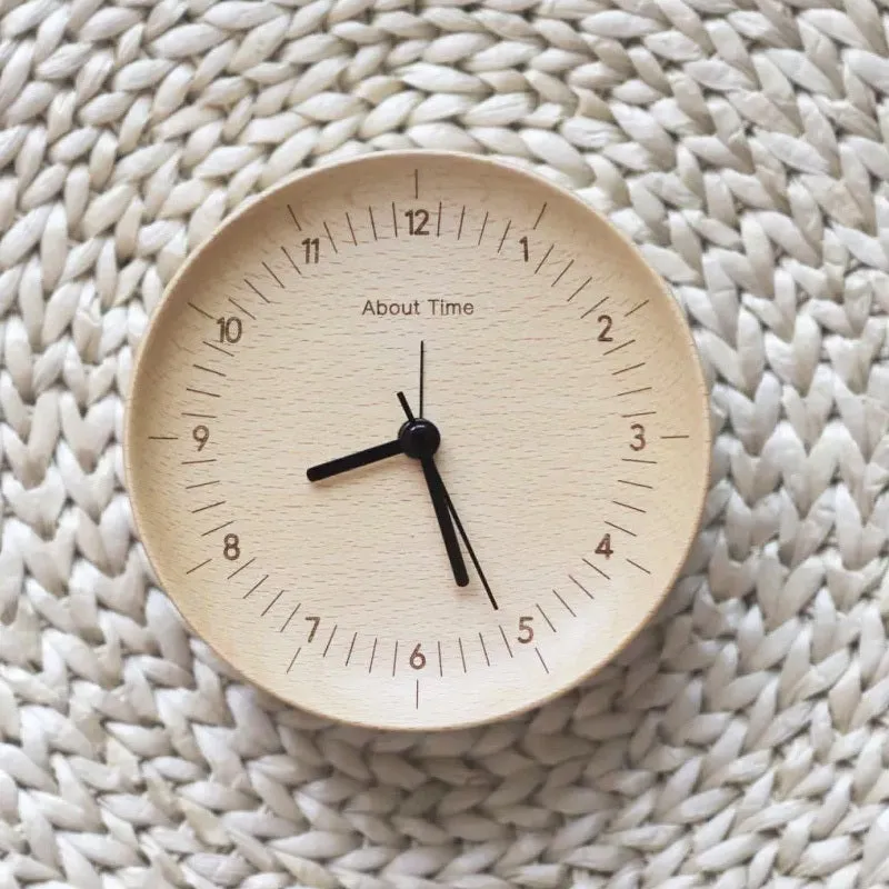 AboutTime log mute pendulum alarm clock in German beech wood, 12cm diameter, featuring Sun brand movement, on a simple desk