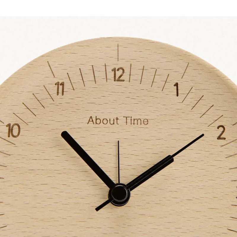 AboutTime log mute pendulum alarm clock in German beech wood, 12cm diameter, featuring Sun brand movement, on a simple desk