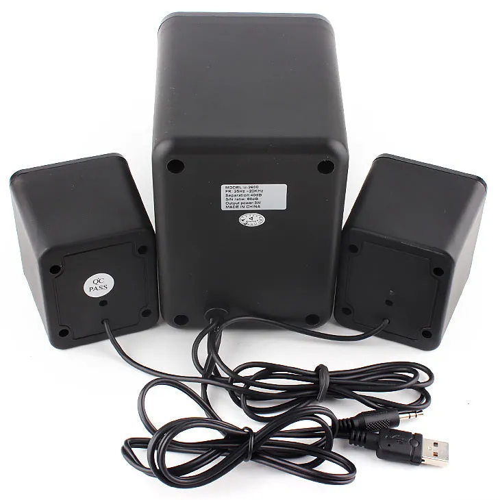 Green 2.1 USB computer speaker with LED lights on a desk next to a laptop.