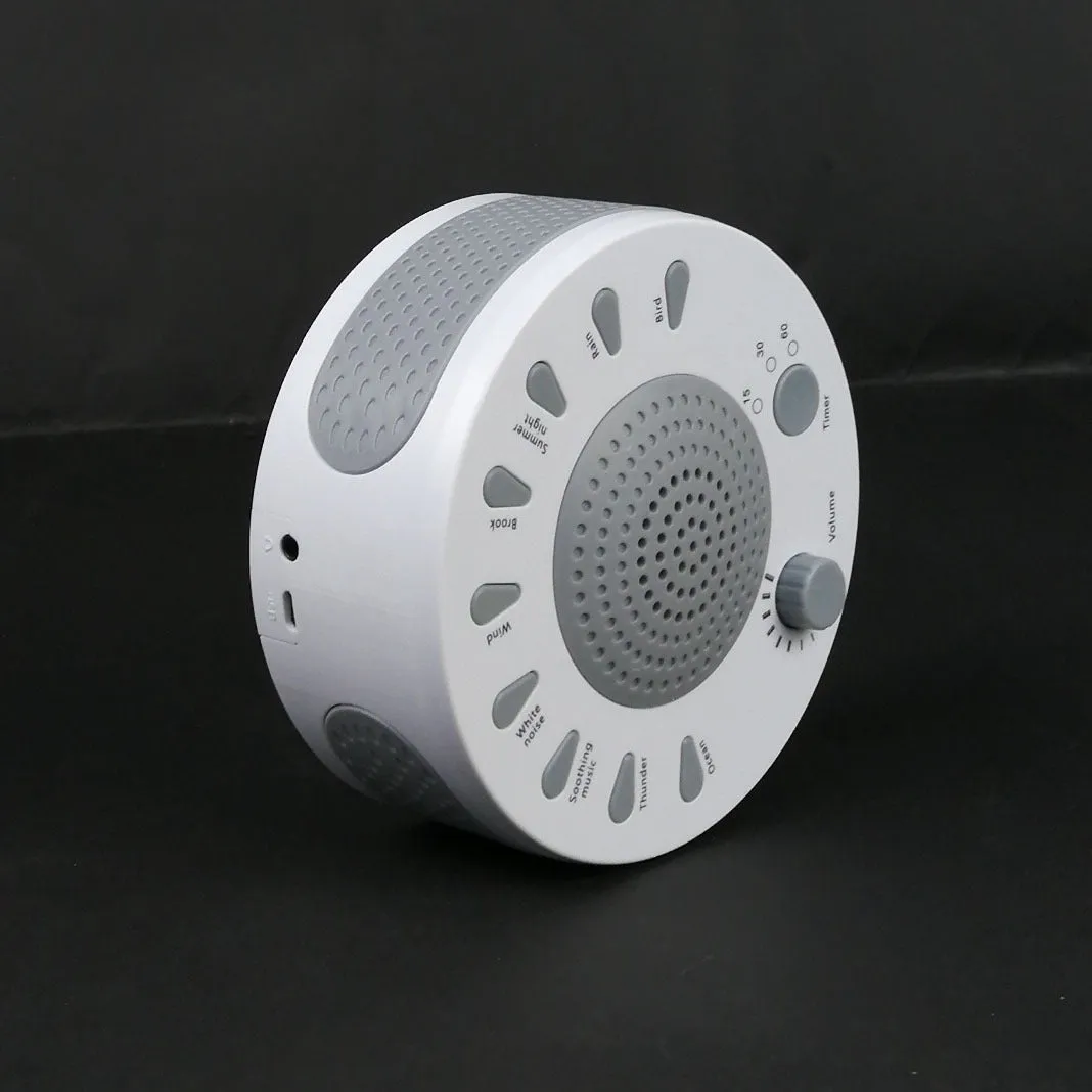 White portable white noise sleep sound machine with control knob on a bedside table.