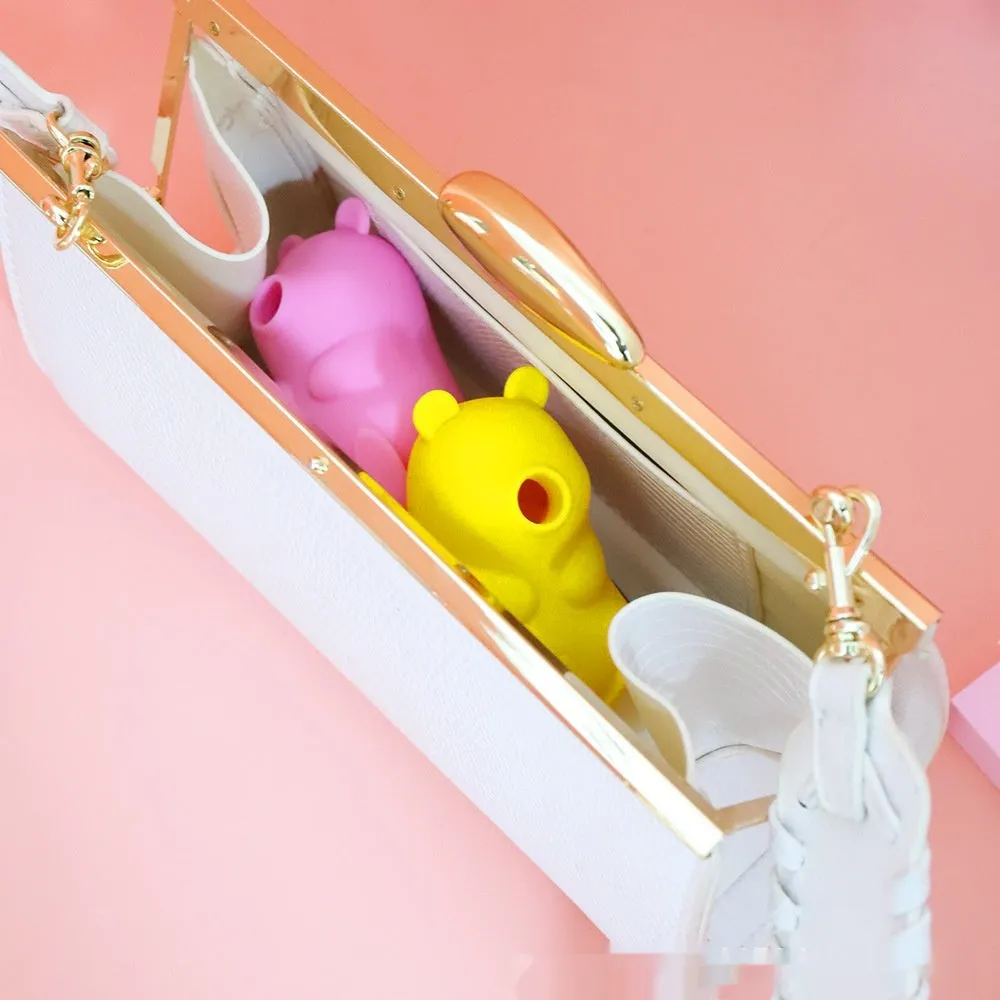 Cute bear-shaped silicone suction massage device in pink and yellow with magnetic charging cable