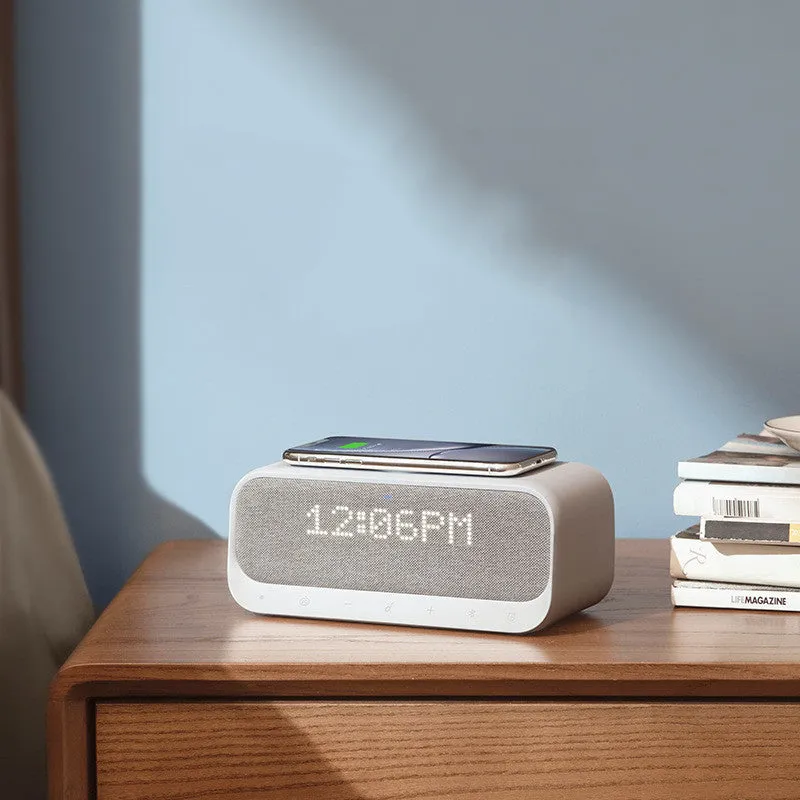 White Anker Soundcore Bluetooth speaker with wireless charging pad and digital clock display