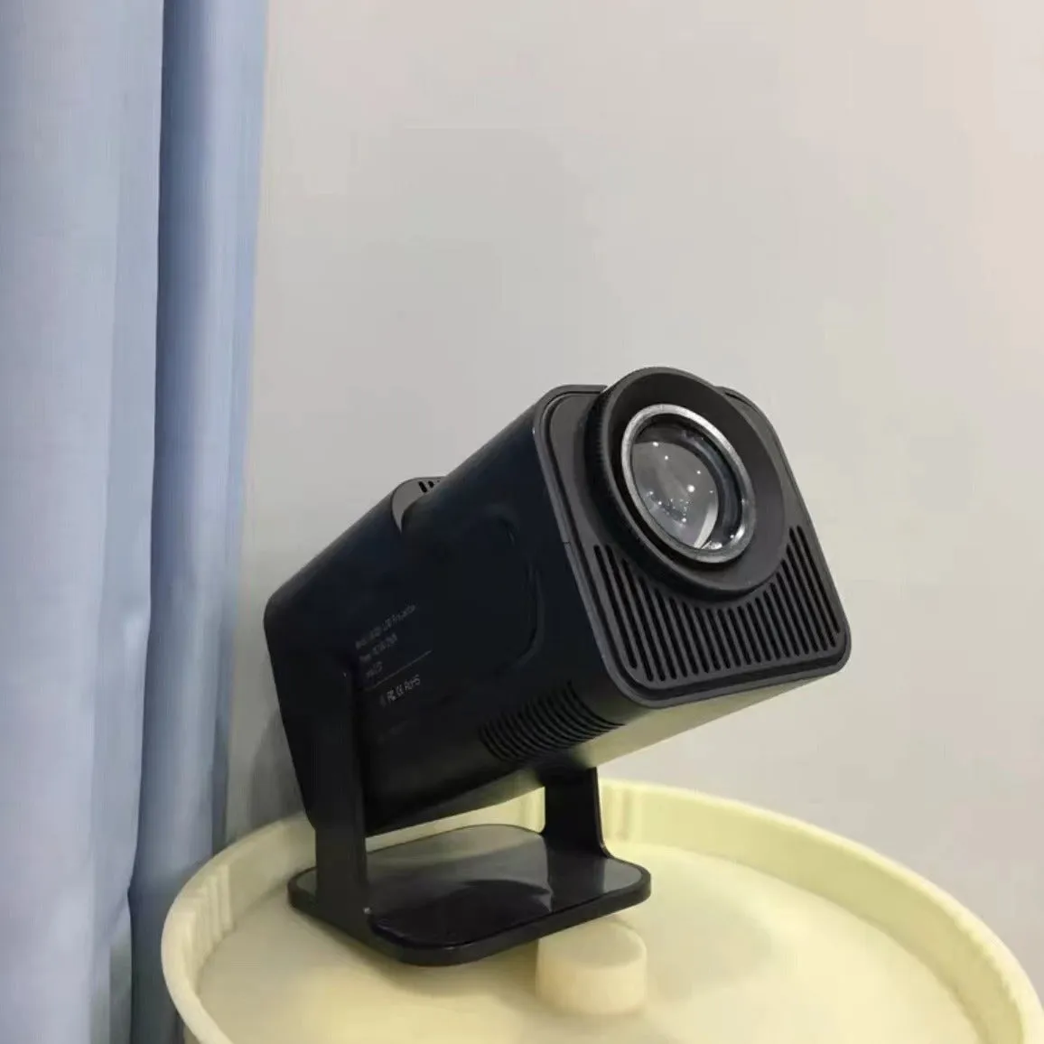 A wireless home gaming projector with a carry handle, showing a 720p HD display on a wall.