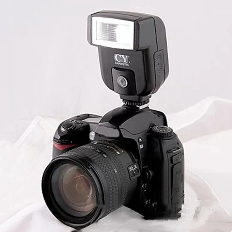 Compact silver SLR camera flash with tilted head mounted on a camera hot shoe