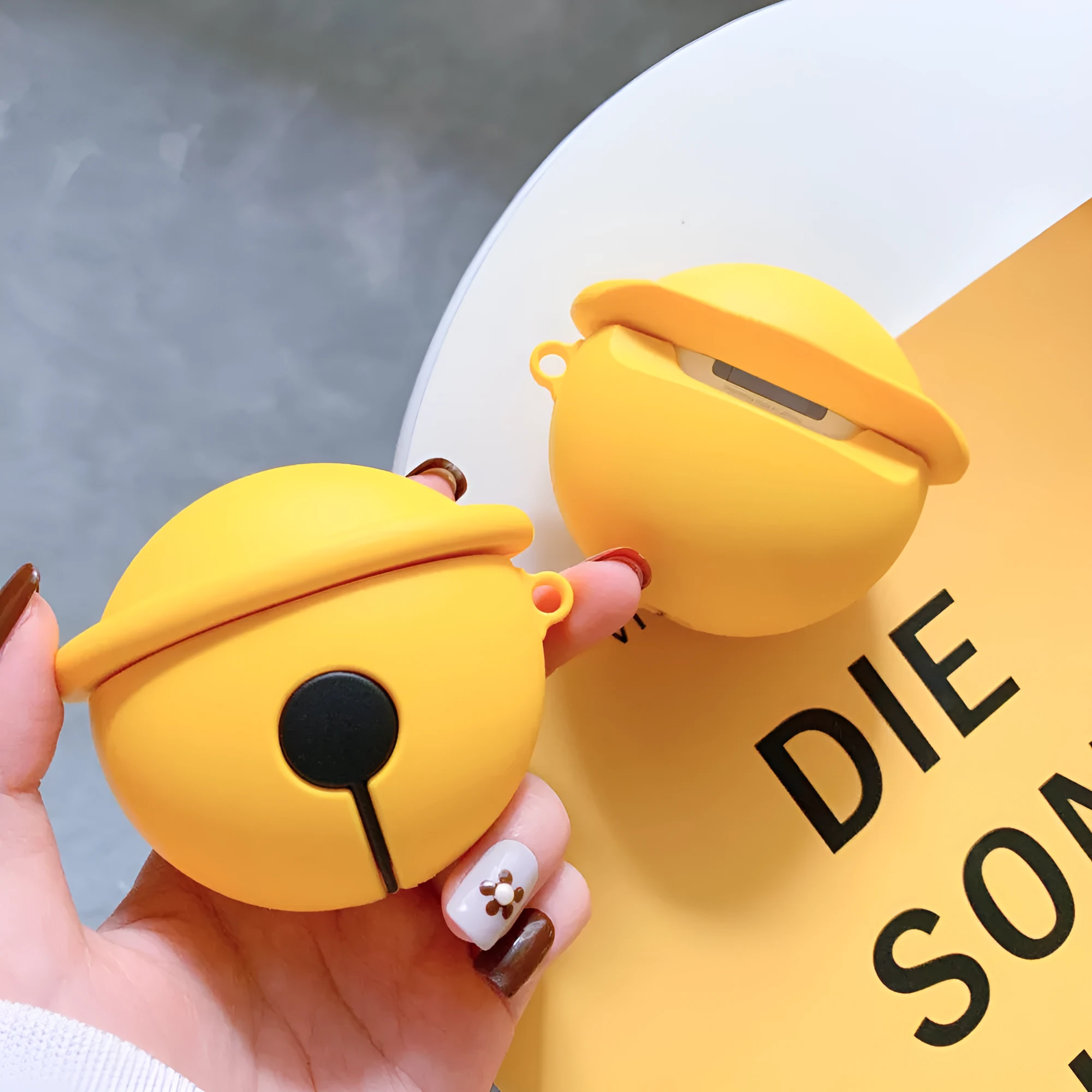 Yellow bell-shaped silicone protective case for AirPods 1st and 2nd generation with a keyring hole.