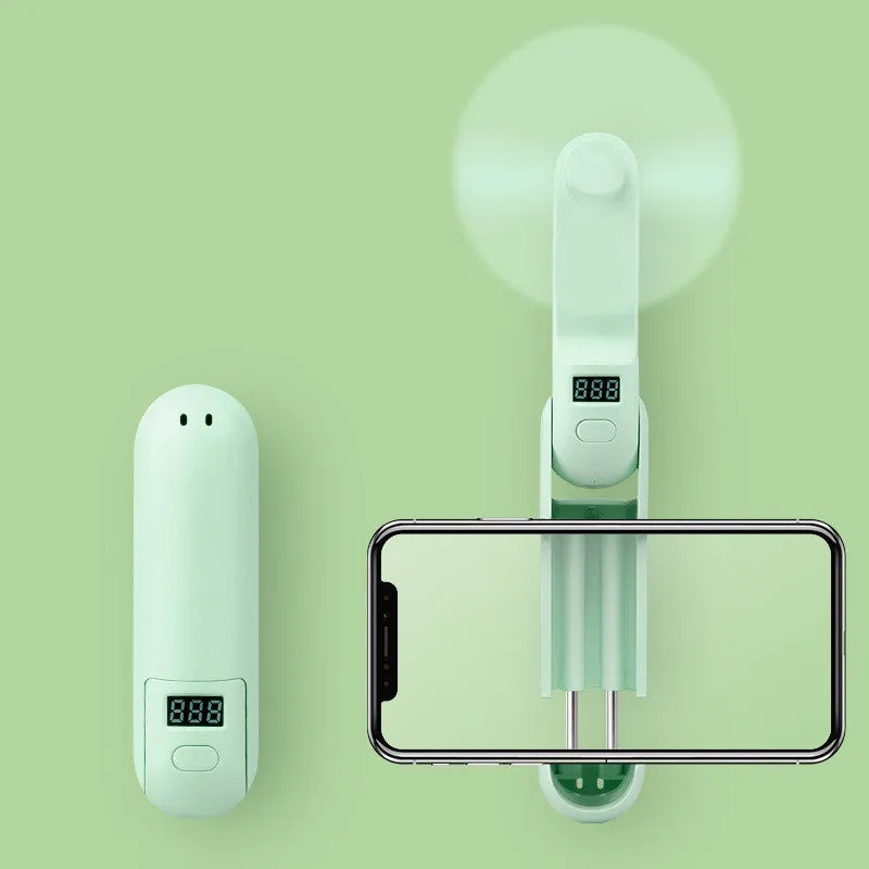 Green folding mini USB fan with plastic blades on a white background.