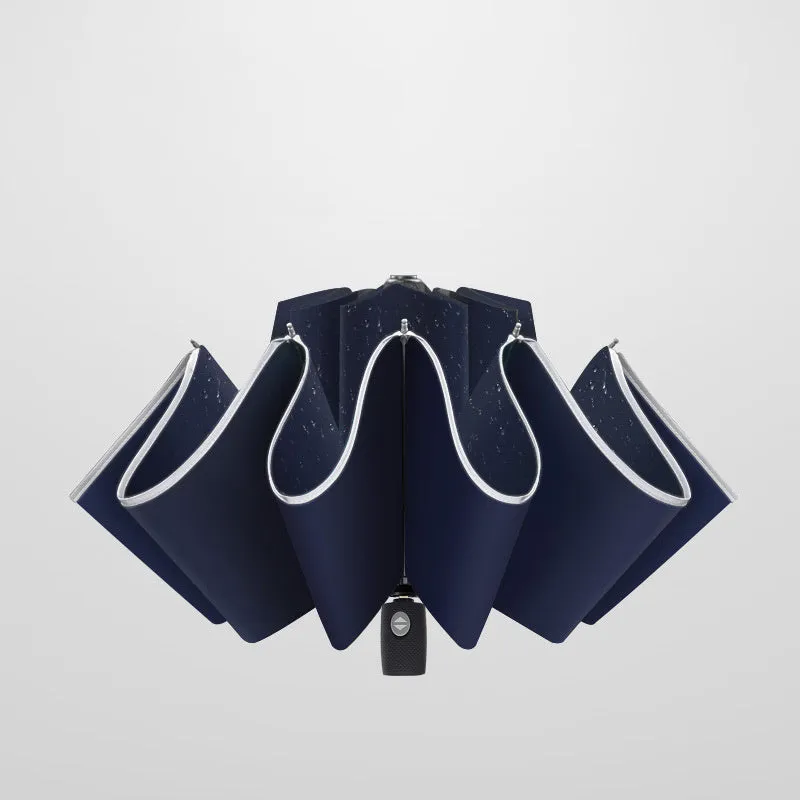 Black automatic reverse folding umbrella with plastic handle, shown closed and demonstrating the reverse mechanism.