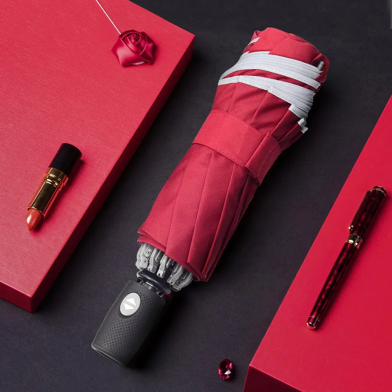 Black automatic reverse folding umbrella with plastic handle, shown closed and demonstrating the reverse mechanism.