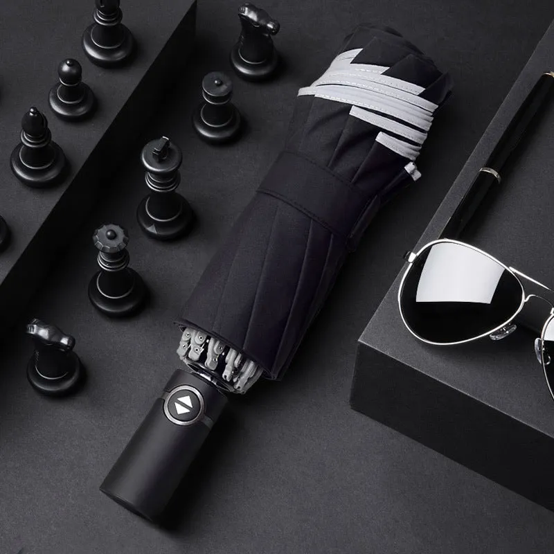 Black automatic reverse folding umbrella with plastic handle, shown closed and demonstrating the reverse mechanism.