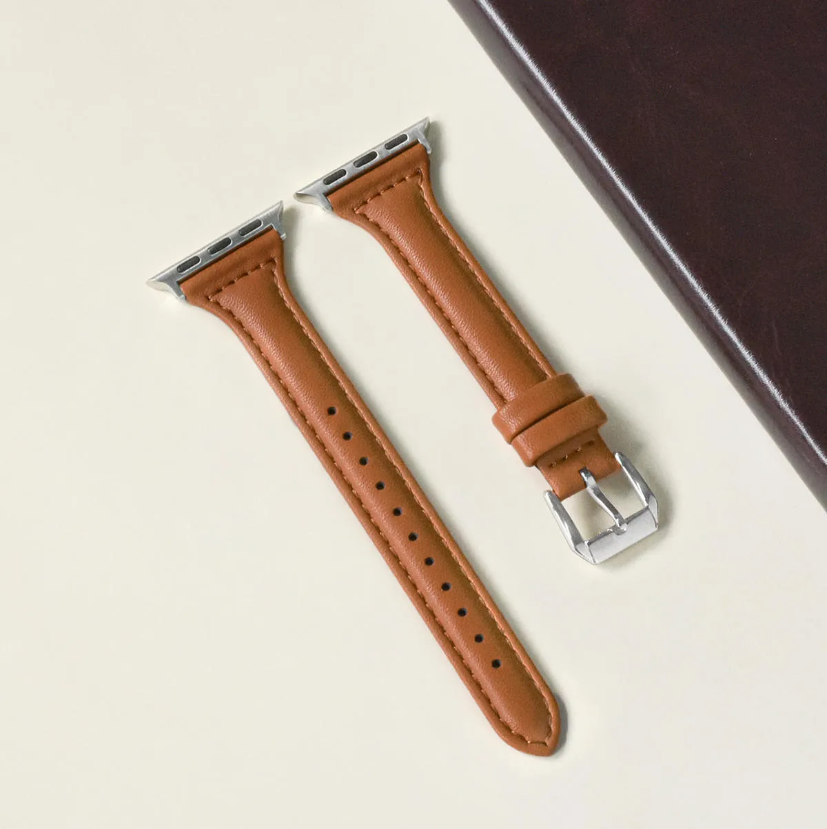 Women's retro slim leather strap for Apple Watch in cream apricot colour on a table