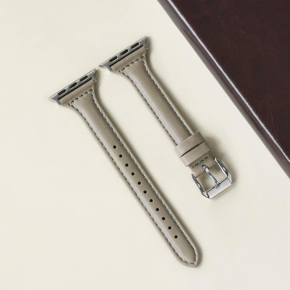 Women's retro slim leather strap for Apple Watch in cream apricot colour on a table