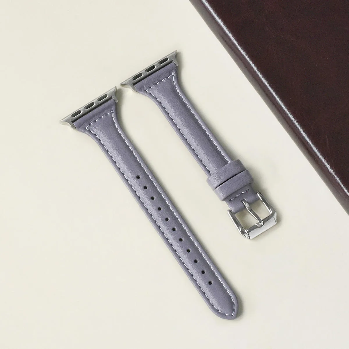 Women's retro slim leather strap for Apple Watch in cream apricot colour on a table